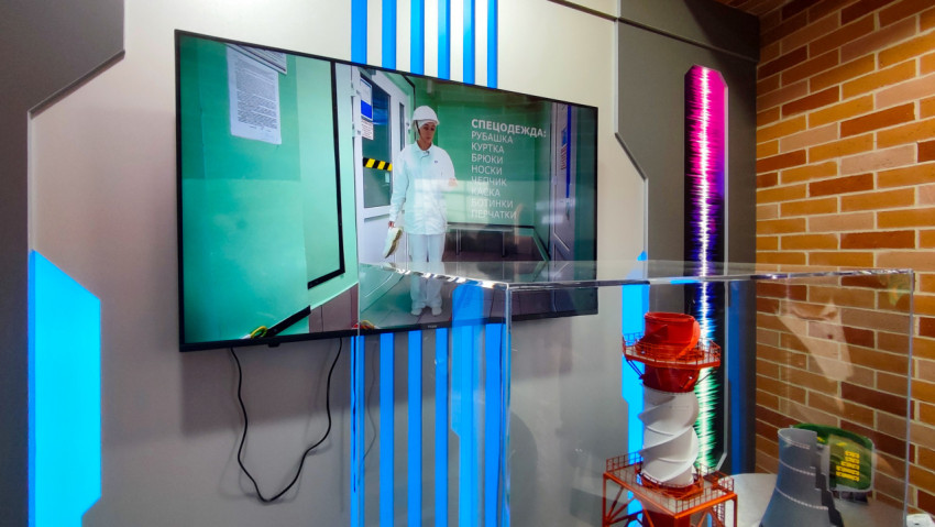 Экран с видеоматериалом и промышленными макетами на выставке