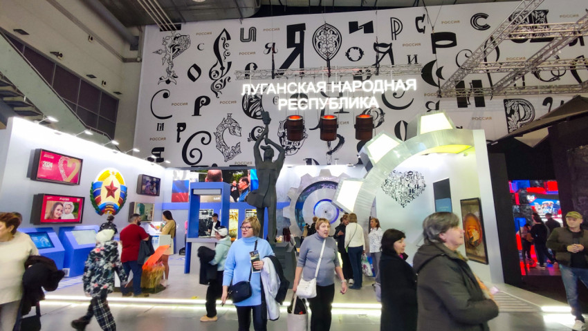 Экспозиция Луганской Народной Республики с центральной скульптурой и подсвеченной аркой