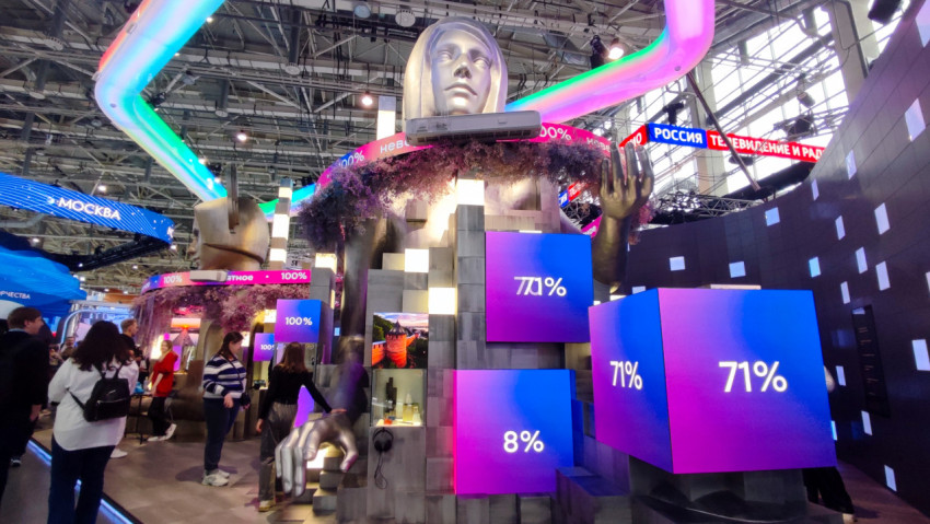 Инсталляция с крупной скульптурой головы и мультимедийными панелями на выставке в павильоне №75