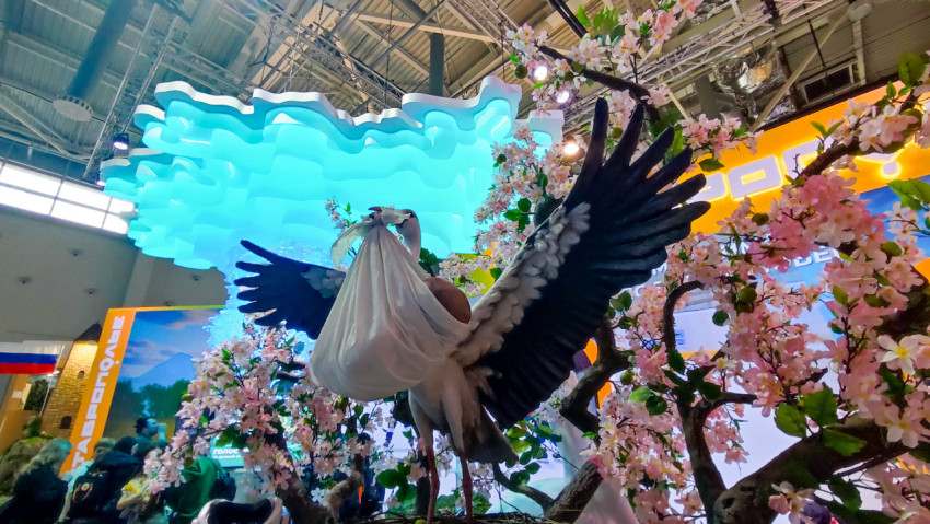 Инсталляция аиста с декоративными деревьями на стенде Ставрополья