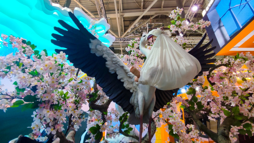 Скульптура аиста с расправленными крыльями и узлом-младенцем на стенде Ставрополья