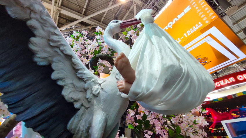 Скульптура аиста с узлом-младенцем на фоне экспозиции Ставрополья