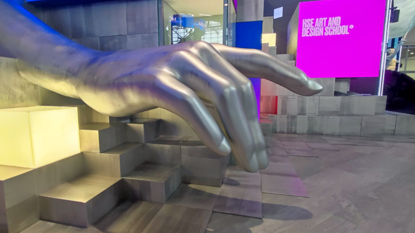 Скульптура руки в индустриальном выставочном пространстве