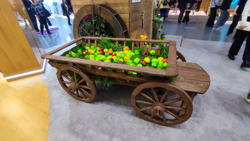 Телега с декоративными фруктами у выставочного стенда