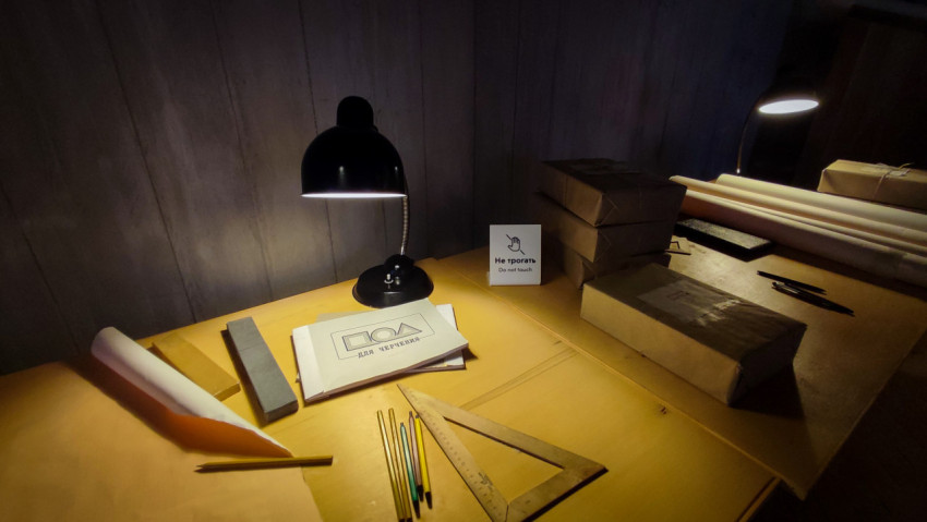 Рабочее место инженера под настольной лампой в павильоне «АТОМ»