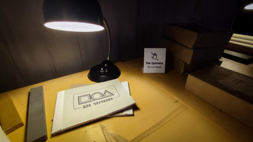 Папка «Для черчения» и настольная лампа рядом с архивными коробками