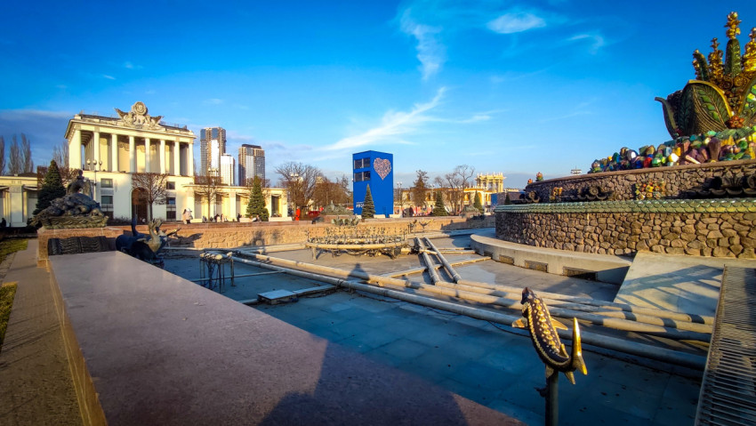 Фонтан «Каменный цветок» и павильон ВДНХ на фоне городской застройки
