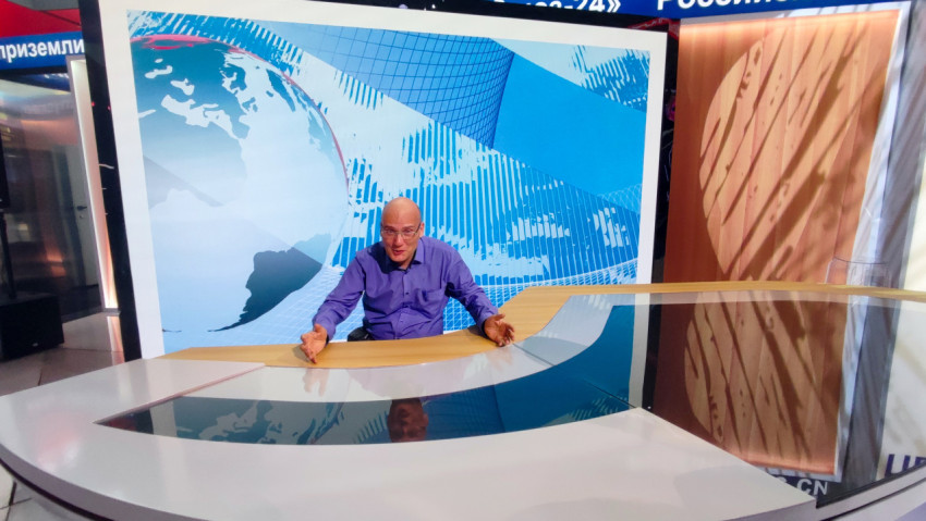 Посетитель у новостного стола на фоне карты мира и студийной графики