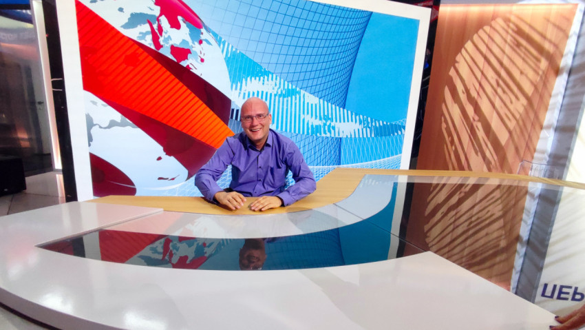 Посетитель за новостным столом демонстрационной студии на выставке-форуме