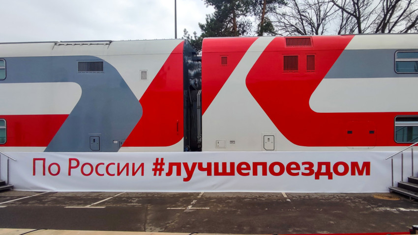 Двухэтажный вагон РЖД с баннером «По России #лучшепоездом»