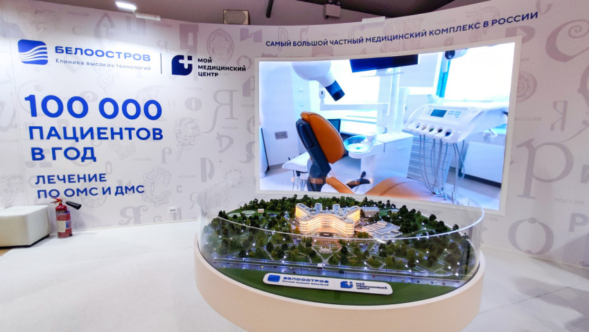 Стенд клиники высоких технологий с макетом и рекламными материалами