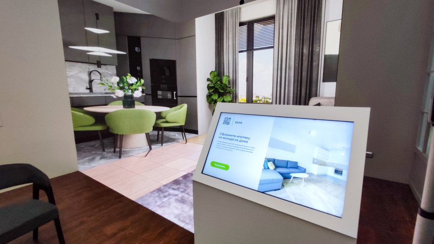 Интерьер зоны ипотечного сервиса с интерактивной стойкой и визуализацией жилого пространства