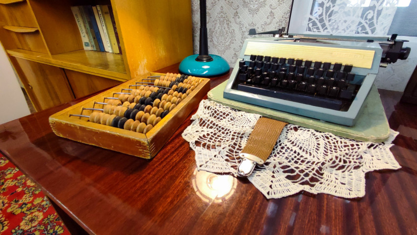 Счёты и пишущая машинка на столе в реконструкции интерьера зоны «Прошлое»