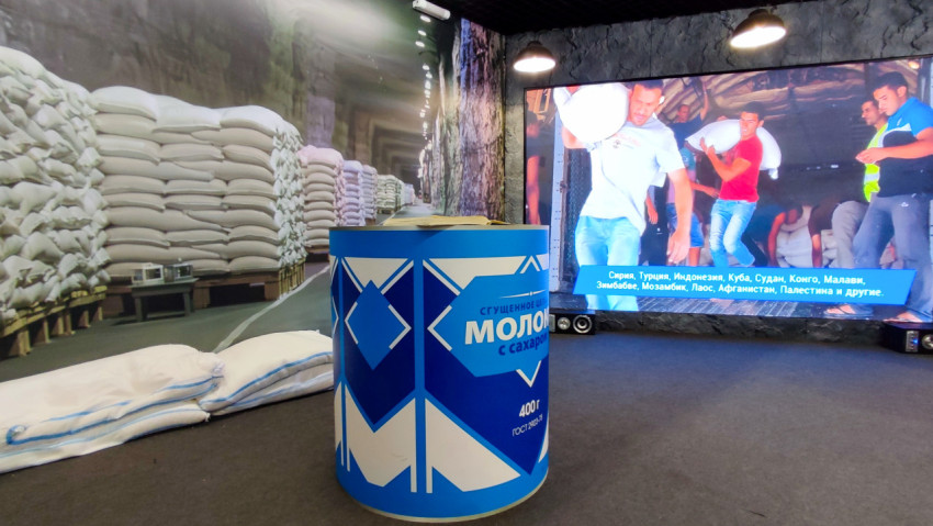 Модель банки сгущённого молока на фоне стенда о международной помощи Росрезерва