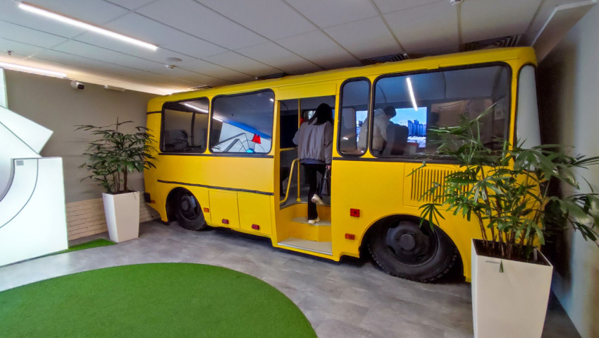 Жёлтый автобус-инсталляция с посетителями в выставочном пространстве