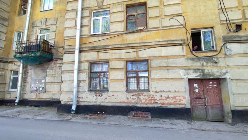 Фасад старого жилого дома с окнами и балконом