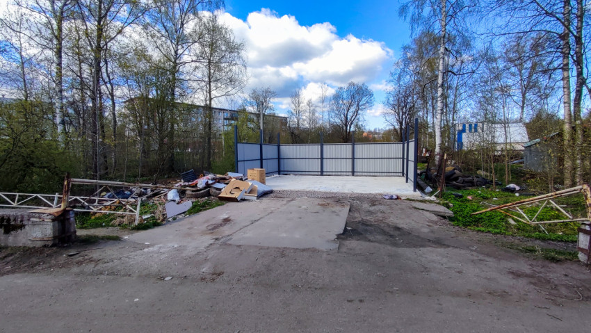 Огороженная пустая площадка для размещения контейнеров