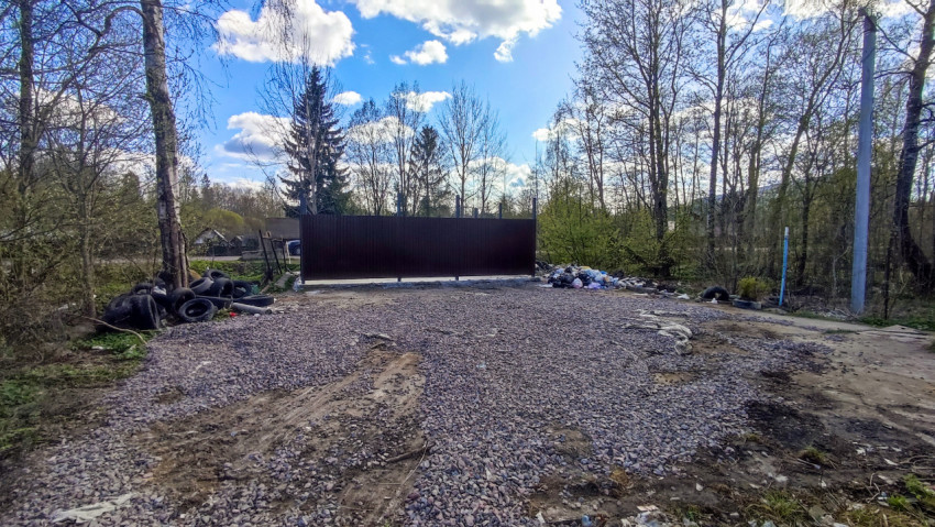 Гравийная площадка и частично ограждённая зона на опушке леса