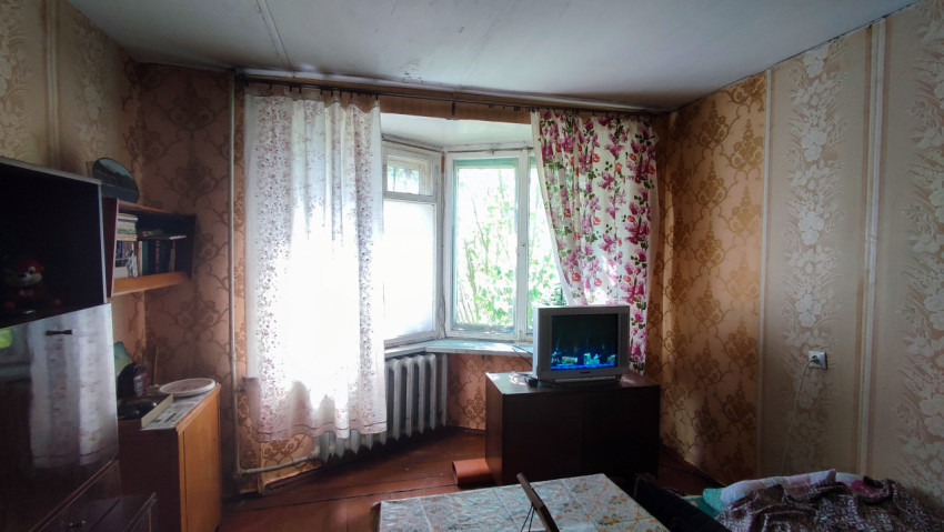 Гостиная с телевизором и старым оконным блоком