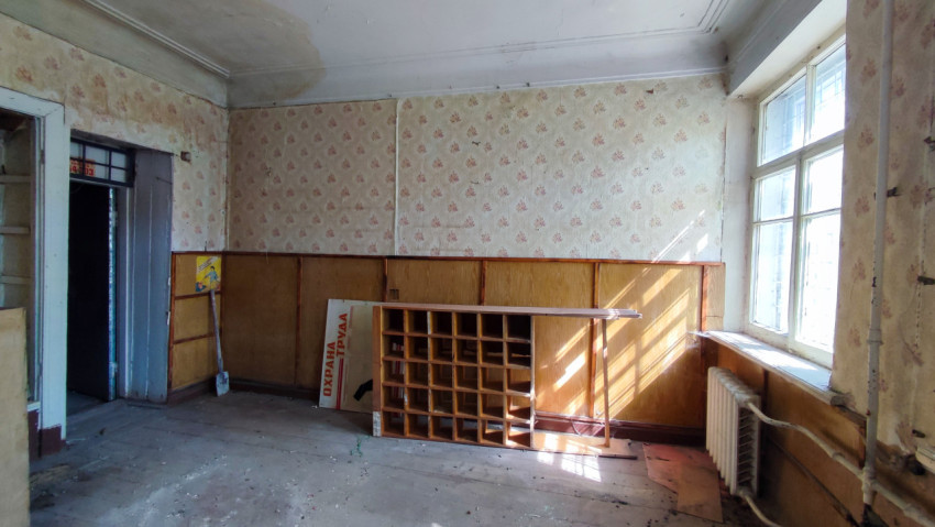 Пустая комната со старой обшивкой стен и деревянным стеллажом