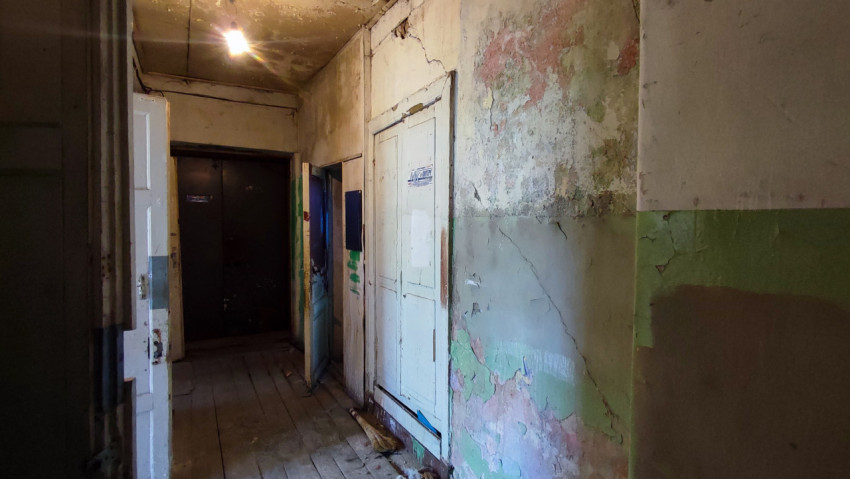 Коридор с осыпавшимися стенами и тусклым освещением