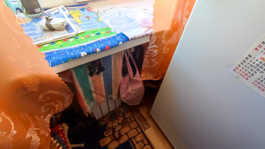 Подоконник с тканевыми салфетками и холодильником рядом