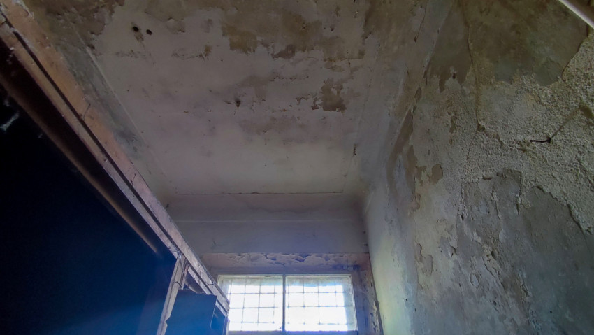 Потолок и стены с повреждённой штукатуркой в старом помещении