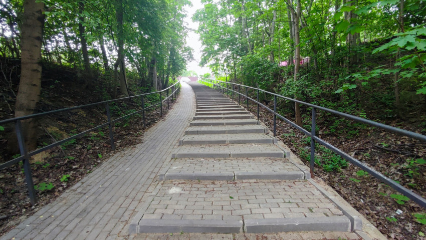 Пешеходная лестница в лесопарковой зоне с поручнями по обеим сторонам