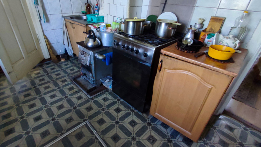 Кухонная зона с плитой, печью и посудой на рабочей поверхности