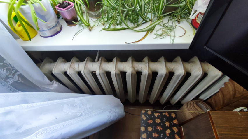 Чугунный радиатор под подоконником с комнатными растениями