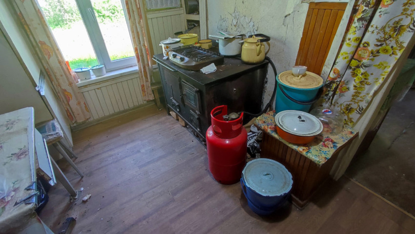 Кухня с газовым баллоном и старой плитой в жилом доме