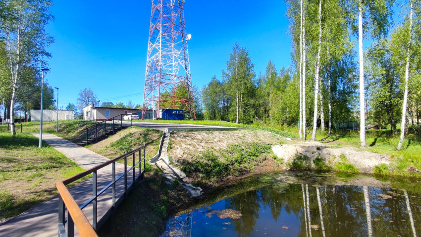 Набережная у небольшого водоёма с лестницей и телекоммуникационной башней