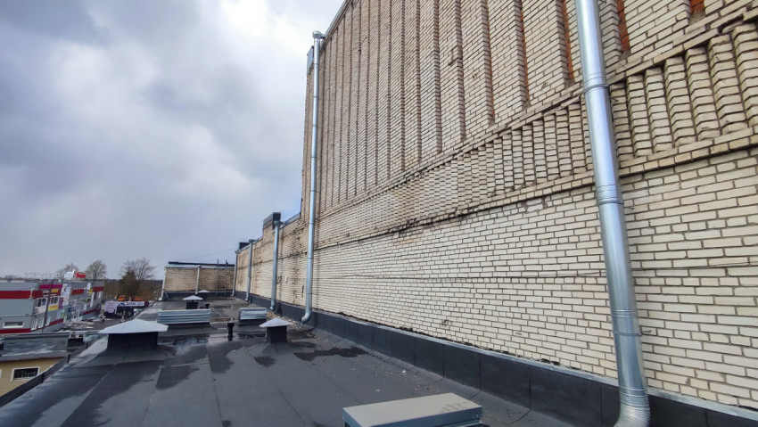 Кирпичная стена промышленного здания и вентиляционные системы на крыше