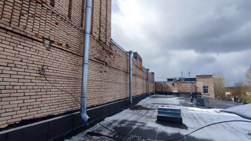 Фрагмент фасада и технические элементы на плоской кровле