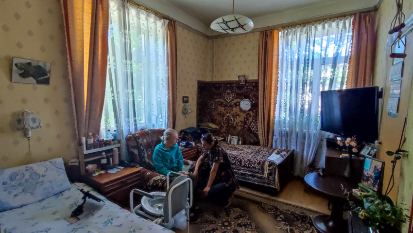 Комната с пожилой женщиной и сиделкой в жилой квартире