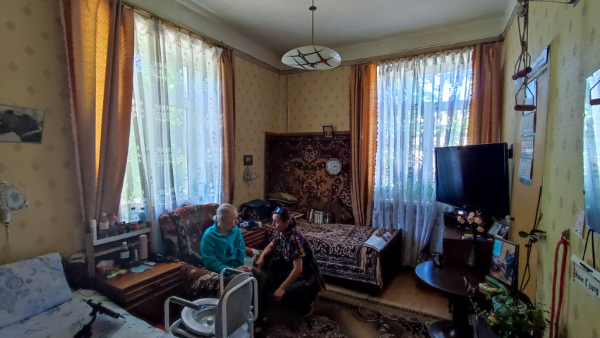 Жилая комната с ковром, телевизором и двумя людьми