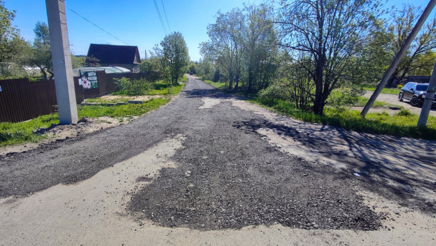 Участок загородной улицы с подсыпкой щебня и линией электропередачи