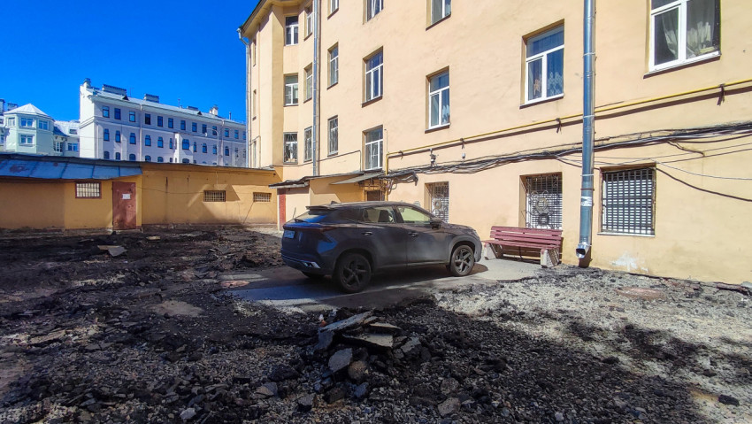 Автомобиль во дворе на участке вскрытого дорожного покрытия