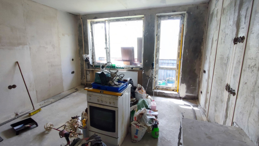 Комната с окнами и строительными материалами в процессе ремонта