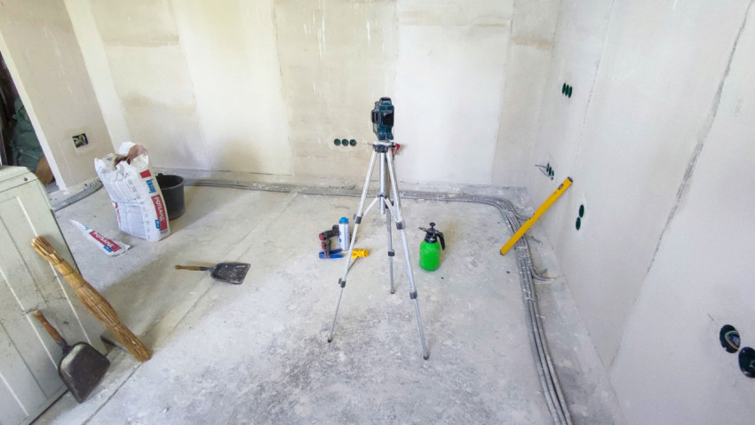 Помещение с инструментами и разметочным штативом в ходе ремонта