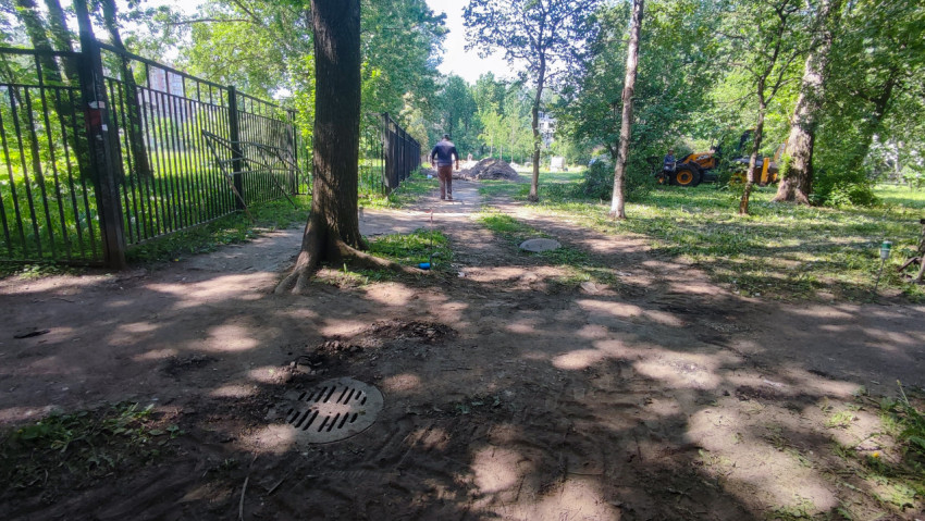 Рабочий осматривает участок перед строительными работами в парковой зоне