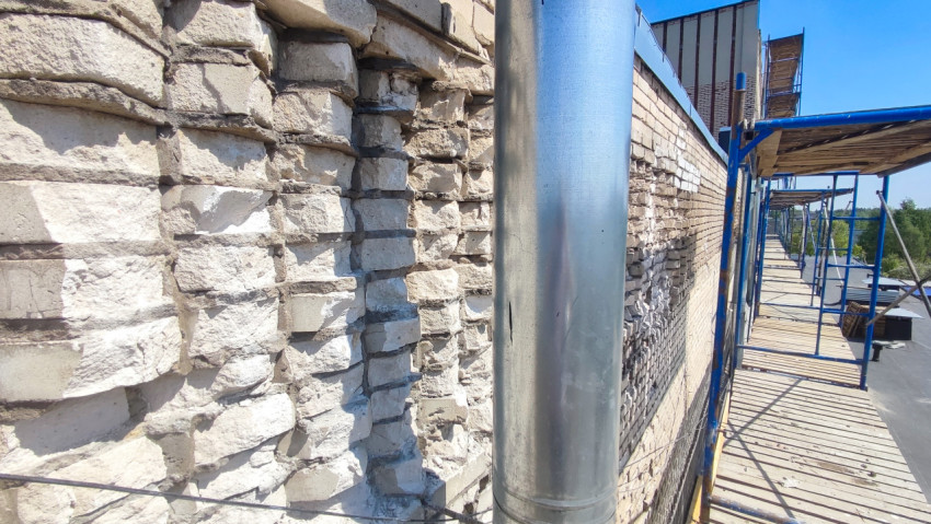 Фрагмент повреждённой кирпичной кладки на реконструируемом фасаде