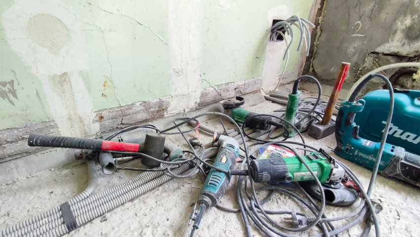 Электроинструменты и гофротрубы на полу ремонтируемого помещения