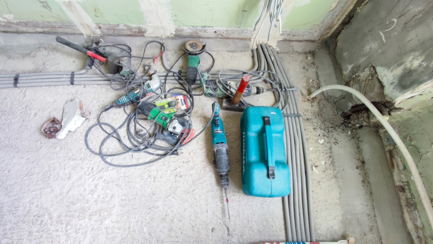 Набор строительных инструментов и кейс Makita на полу помещения