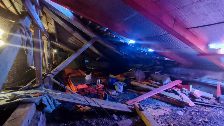 Чердак жилого дома с временными опорами и строительными материалами