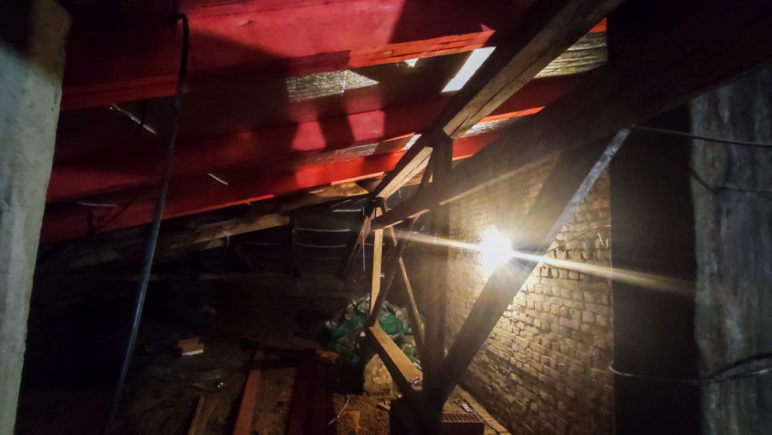 Чердачное помещение с деревянными стропилами и подсветкой от лампы