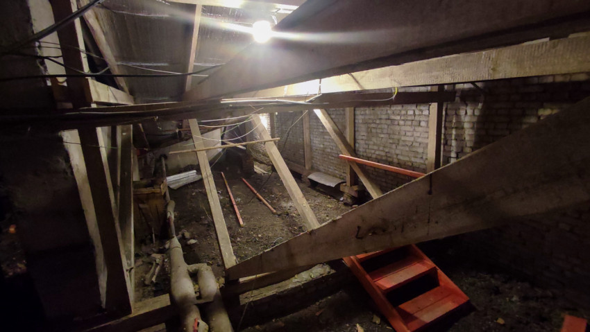 Деревянные балки и инженерные трубы в чердачном помещении