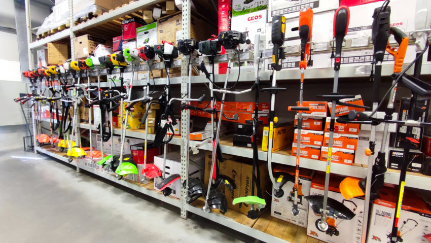 Ряд триммеров и кусторезов на металлическом стеллаже