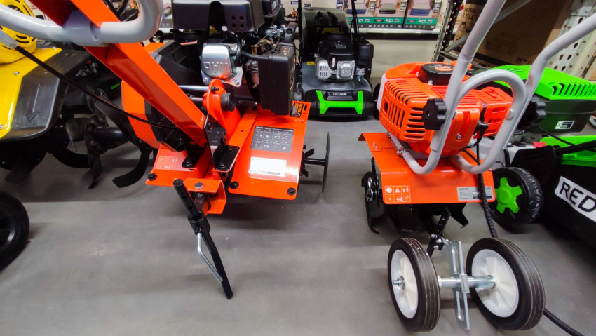 Садовые культиваторы с бензиновыми двигателями на полу торговой зоны