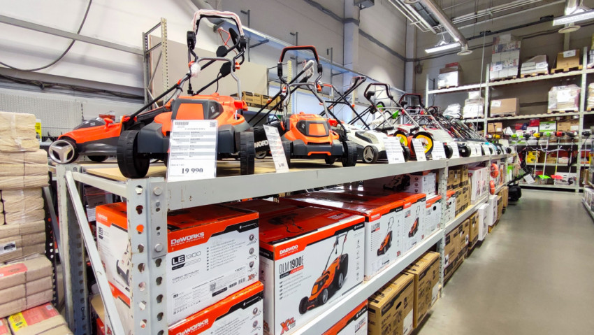 Ряд газонокосилок Daewoo и других брендов на полке магазина